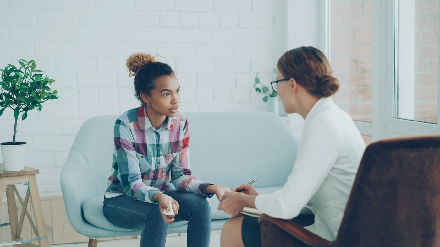 A young woman in a bright, supportive therapy session