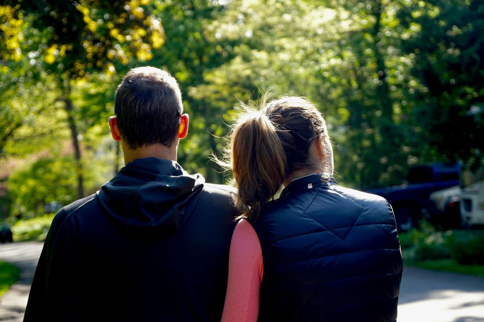 A couple walking together on a tree-lined path